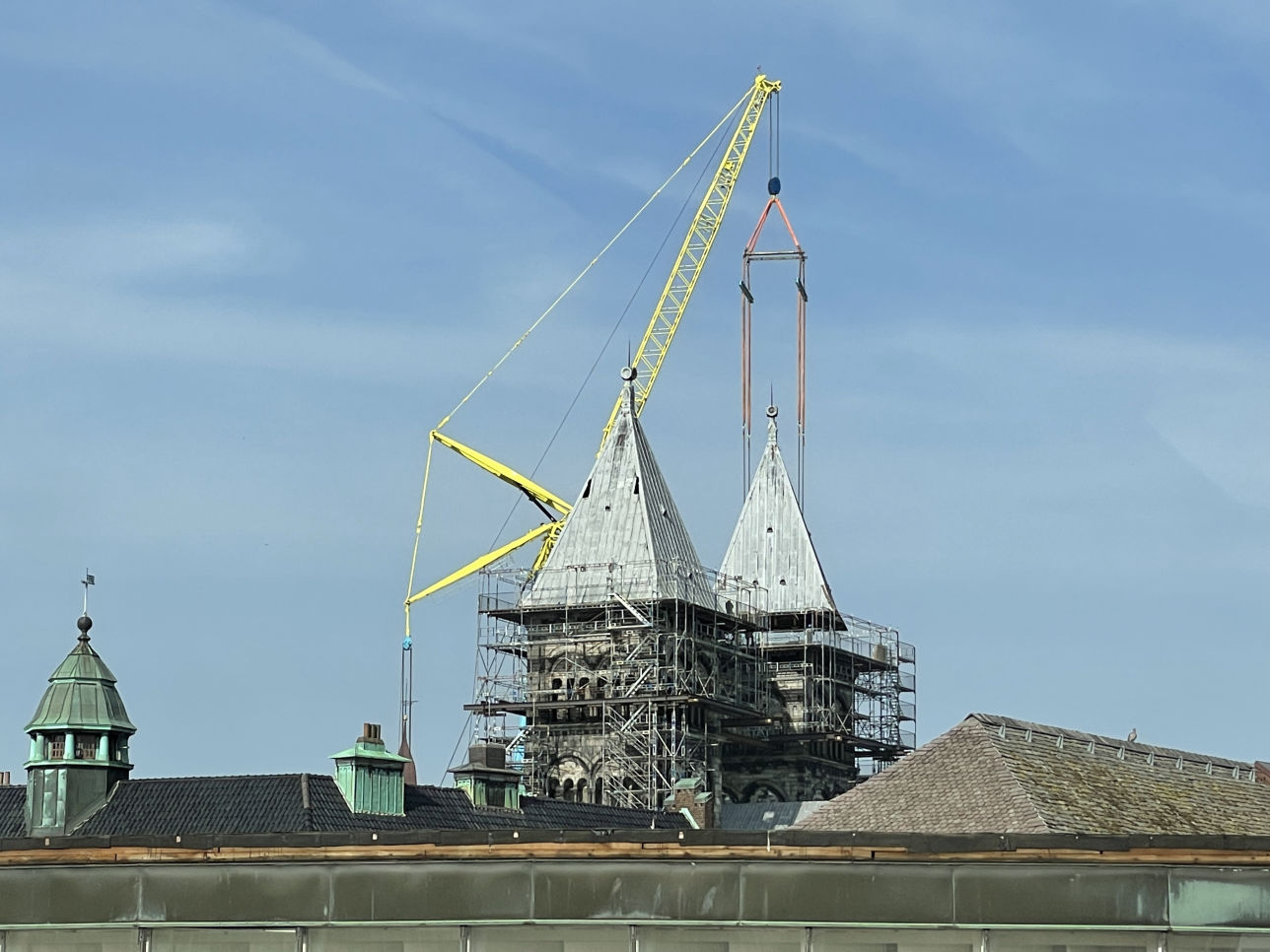 En tornhuv lyfts ned från Lunds domkyrka under restaureringen, fotograferad från Botulfstandläkarna